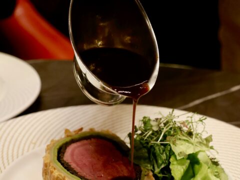 Dunkler Rotwein-Jus wird über Rinderfilet gegossen