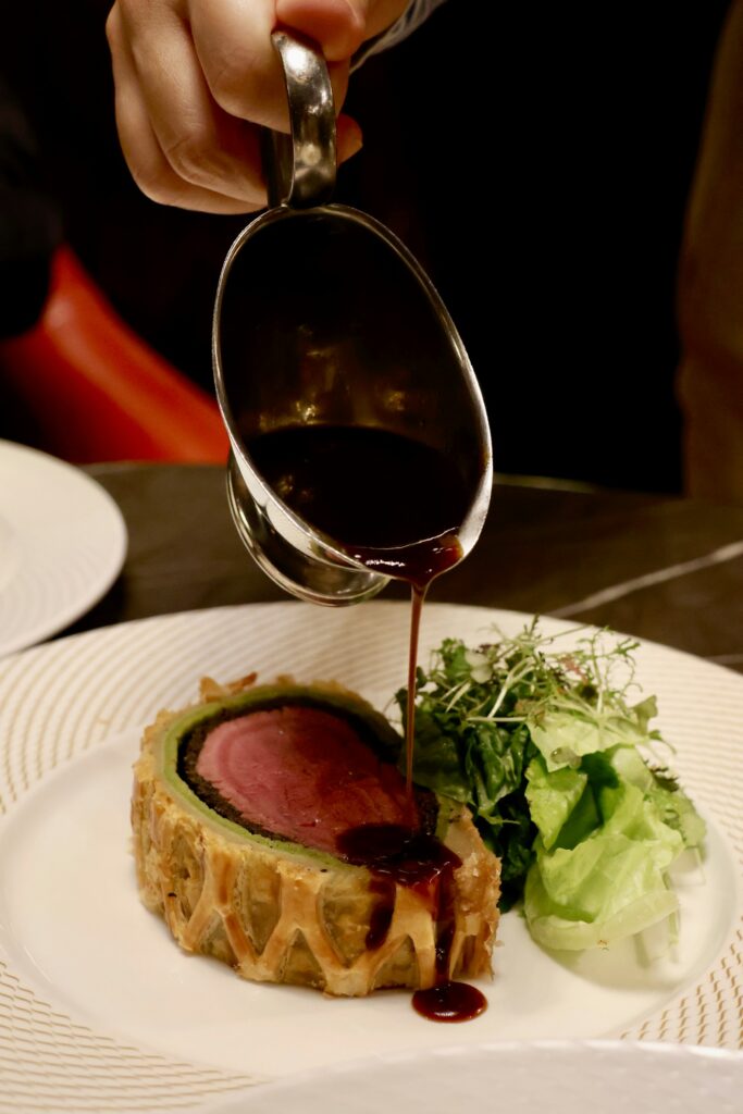 Dunkler Rotwein-Jus wird über Rinderfilet gegossen